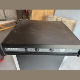 Černý výkonový zesilovač v kovovém šasi. Na předním panelu jsou nápisy DAS ELECTRONIC SERIES a L-2 HIGH PERFORMANCE POWER AMPLIFIER. Zařízení má vypí…