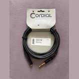 Černý audio kabel s pozlacenými konektory, upevněný na originálním papírovém obalu. Na obalu je nápis CORDIAL essentials a text Versatile fundamental…