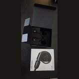 Černé špunty do uší v otevřené černé krabici. Vedle krabice je položen bílý manuál s fotografií sluchátka a nápisy audio-technica a ATH-E40. Povrchy…