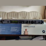 Šedý rackový procesor s nápisem VOICEWORKS a logem TC-HELICON. Zařízení má digitální displej, několik tlačítek, dva otočné ovladače a konektory na za…