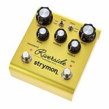 Zlatý kytarový efekt s nápisy Riverside multistage drive a strymon. Pedál má pět černých ovládacích knoflíků s bílými vršekmi a popisky DRIVE, BASS,…