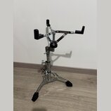 Chromovaný stojan na hudební nástroj s černými gumovými oporami. Stojan má tříramenný základ s protiskluzovými gumovými patkami a teleskopický středo…