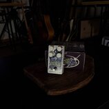 Bílý efekt pedál s nápisy MOD a electro-harmonix. Pedál má čtyři bílé ovládací knoflíky s popisky DEPTH, RATE, ATTACK a SUSTAIN. Je umístěn na dřevěn…
