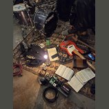 Fotografie zachycuje hudební vybavení rozložené na vzorném koberci. Je zde vidět bicí souprava s nápisem SONOR na basovém bubně, červená elektrická b…