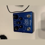 Modrý efekt pedál značky NUX s nápisem Solid Studio I.R.E. Power Amp Simulator. Zařízení má pět černých otočných ovladačů a dva stomečkové spínače oz…