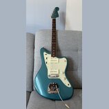 Modrá elektrická kytara s bílým pickguardem a hnědým hmatníkem. Na hlavě je viditelné logo Fender. Kytara má jeden snímač typu humbucker u kobylky a…