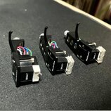 Tři černé gramofonové hlavy s bílými stylosy. Na každé je viditelný nápis Technics a označení modelu M44-7. Na bílých stylosech je nápis SHURE. Všech…