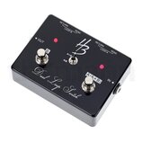 Černý efekt pedál s nápisem Dual Loop Switch. Na horní straně je logo HB, přepínač s označením A/B a A+B, dva stoupací spínače s popisky B a A/(A+B)…