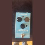 Modře barevný efekt pedál s nápisy tc electronic, SKYSURFER a REVERB. Na horní straně jsou tři černé ovládací knoflíky s popisky REVERB, MIX a TONE,…