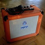Kytarový kombozesilovač v oranžovém vinylu s bílou texturovanou přední síťovkou. Na síťovce je umístěno logo s nápisem ORANGE a nad ním barevný znak.…