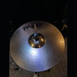 Kruhový činel z lehce žlutého kovu s koncentrickými rýhami na povrchu. Na povrchu je černý nápis Paiste 2002 a pod ním text 16" HI-HAT TOP. Činel je…