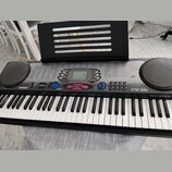 Černý digitální klavír značky CASIO, model CTK-551 s nápisem TOUCH RESPONSE. Nástroj má bílé a černé klávesy, dvě integrovaná kulatáh reproduktory po…