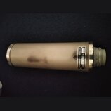 Kondenzátorový mikrofon s kovovým tělem v matné stříbrno-šedé barvě. Na boku je nalepený štítek s nápisem „NEUMANN & CO. GEFELL i.V. Type CMV 3 Nr. 9…