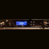 Černý rackový接收器 s modrým displejem, na kterém je zobrazen text STEREO, 478.000 MHzs, AUDIO a další hodnoty (L R, GAIN). Na předním panelu jsou nápis…