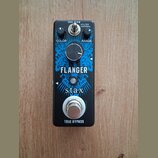 Černý efekt pedál s modrým grafickým motivem. Na zařízení jsou nápisy TRUE BYPASS, Stax a FLANGER. Pedál má jeden ovládací knoflík s popisky COLOR a…