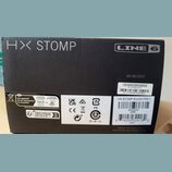 Černá papírová krabice s bílými nápisy HX STOMP a LINE 6. Na pravé straně je vytištěno číslo 50-50-0221 a dvě nálepky; první obsahuje text PN: 99-080…