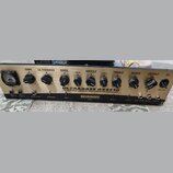 Zlatý basový zesilovač s černými ovládacími knoflíky a analogovým VU metrem vlevo. Na předním panelu jsou nápisy ULTRABASS BX4410, 450-WATT BASS AMPL…