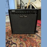 Černý kytarový kombozesilovač s texturovaným povrchem a černou přední síťovkou. Na horním ovládacím panelu je nápis HB-40MFX 40W GUITAR AMP a logo Ha…