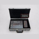 V otevřeném hliníkovém kufru s černým vnitřním polstrováním se nachází šedý kytarový efektový pedalboard a expresní pedál. Na horní části přístroje j…