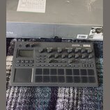 Šedý sampler/sekvencer značky KORG s nápisem electribe MUSIC PRODUCTION STATION. Zařízení obsahuje několik otočných potenciometrů, digitální displej…