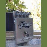 Stříbrný efekt pedál s kovovým povrchem. Na přední straně je nápis THE JACKHAMMER JH-1 a ve spodní části logo Marshall. V horní části jsou čtyři kovo…