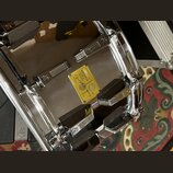 Detailní pohled na chromovaný obrub bubnu s několika kovovými mechanismy. Uprostřed je žlutý štítek s nápisy SONOR SIGNATURE SERIES 50, Made in Germa…