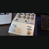Bílý efekt pedál s nápisy BOSS DIGITAL DELAY DD-200. Na horní části jsou ovládací knoflíky a přepínače s popisy funkcí, jako je TAP DIVISION nebo MEM…