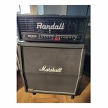 Černý kytarový kombozesilovač značky Randall, model RH300 G3 Plus, s ovládacím panelem obsahujícím několik potenciometrů a přepínačů. Je umístěn na č…