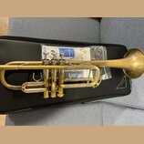 Zlatý mosazný kornét položený na černém pouzdře. Na nástroji je v horní části viditelné logo YAMAHA a nápis MODEL 230. Povrch nástroje vykazuje známk…