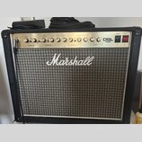 Kytarový kombozesilovač značky Marshall s modelem DSL 40C. Má černý kryt, stříbrný ovládací panel s řadou knoflíků a šedý textilní přední grill. Na p…