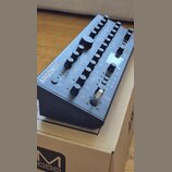 Černý syntetizátor s nápisem ARGON8M a doplňkovým textem POLYPHONIC TABLE WAVE SYNTHESIZER MODULE. Přístroj má kovové tělo s mnoha ovládacími knoflík…