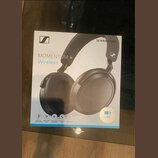 Fotografie znázorňuje krabici s černými bezdrátovými sluchatky. Na obalu je uveden nápis SENNHEISER, logo značky a model MOMENTUM 4 Wireless. V dolní…
