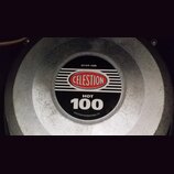 Detailní pohled na střed reproduktoru s kovovým šedým krytem. Uprostřed je černý štít s červeným logem CELESTION a bílými nápisy HOT 100, G12T-100 a…