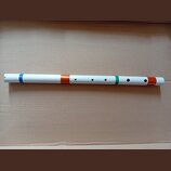 Bílá fletna s barevnými pruhy v modré, oranžové a zelené barvě. Nástroj má několik hracích otvorů v horní části trupu. Na povrchu nejsou vidět žádné…