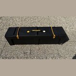Černý plastový přepravní kufr s koly. Na horní části je umístěno logo HARDCASE a malý žlutý štítek s nečitelným nápisem. Kufr je zajištěn dvěma žlutý…