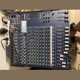 Modrý mixážní pult značky YAMAHA s označením MG166C USB. Zařízení obsahuje řadu vertikálních kanálů s knoflíky v červené, zelené a žluté barvě a fade…