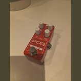 Červený efekt pedál s bílými ovládacími knoflíky. Na horní straně jsou nápisy ehx, POG a NYC • DSP, dále popisky DRY, SUB OCTAVE, TONE a FILTER. Povr…