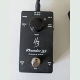 Černý výkonový zesilovač v kovovém boxu s nápisy Thunder 99 a POWER AMP. Uprostřed je logo HB a ovratový knoflík s popiskem VOLUME. Zařízení má vstup…
