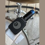 Černý dynamický mikrofon s mřížkou, umístěný na bílém bubnu. Na těle mikrofonu je bílý nápis SENNHEISER e906 a logo značky. Na horní části těla je mo…