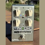 Kovový efekt pedál stříbrné barvy s nápisem C4 SYNTH a logem SOURCE AUDIO v dolní části. Zařízení má čtyři krémové ovládací knoflíky s popisky INPUT…