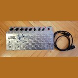 Kovové zařízení stříbrné barvy s nápisy ENGL a TUBE TONER. Na přední straně se nachází šest tlačítek s popisky CLEAN MIDI 1/6, CRUNCH MIDI 2/7, SOFT…