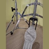 Detailní pohled na chromovaný basový pedál. Na šlapadle je vyražen nápis SLINGERLAND CHICAGO USA. Na horní části stojanu je viditelný štítek s nápise…