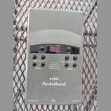 Šedý plastový přístroj s nápisy KAWAI a Pocketband. Na přední straně je digitální displej s červenými číslicemi a několik ovládacích tlačítek. Jsou z…
