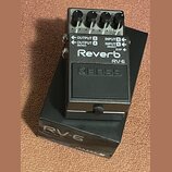 Černý efekt pedál s nápisy Reverb, RV-6 a logem BOSS. Na horní části jsou čtyři ovládací knoflíky a přepínače s nečitelnými popisy. Na boku jsou vstu…