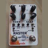 Bílý efekt pedál s nápisy RASTER™, Red Panda a SHIFT. Na horní části jsou šest černých otočných ovladačů s bílými ukazateli a popisy SHIFT, CTRL, DEL…