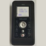 Černý přenosný digitální nahrávač značky KORG. Na displeji je text KORG SR1 SOUND ON a fialový sloupec indikátoru. Pod displejem je nápis SOUND on SO…