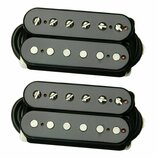 Dvě identické sady černých humbucker snímačů. Horní snímač v každé sadě má viditelné šroubovací póly, spodní snímač má hladké kovové póly. Povrch je…