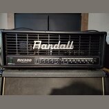 Černý kytarový zesilovač s mřížkou v horní části, na které je bílé logo Randall. Na ovládacím panelu jsou nápisy RH300, 300W TUBE/MOSFET VALVE-DYNAMI…
