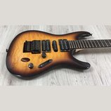 Elektrická kytara s prohýbaným topem v žlutě-hnědém sunburst provedení s viditnou strukturou dřeva. Nástroj má tři snímače (dvě humbuckery a jeden si…