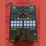 Černý DJ kontrolér s množstvím tlačítek, posuvníků a otočných knoflíků. Na přístroji jsou viditelné nápisy SERATO FX UNIT 1, SERATO FX UNIT 2, ELITE…